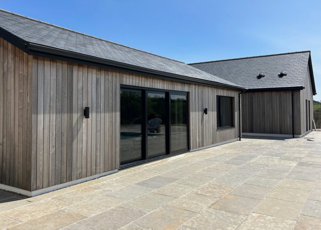 New build bungalow, with Brimstone cladding and bright sky on a sunny day.