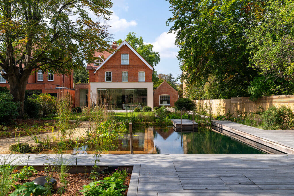 Brimstone ash decking surrounds the outdoor natural swimming pool